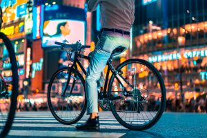 man riding on bike near buildings during nighttime
