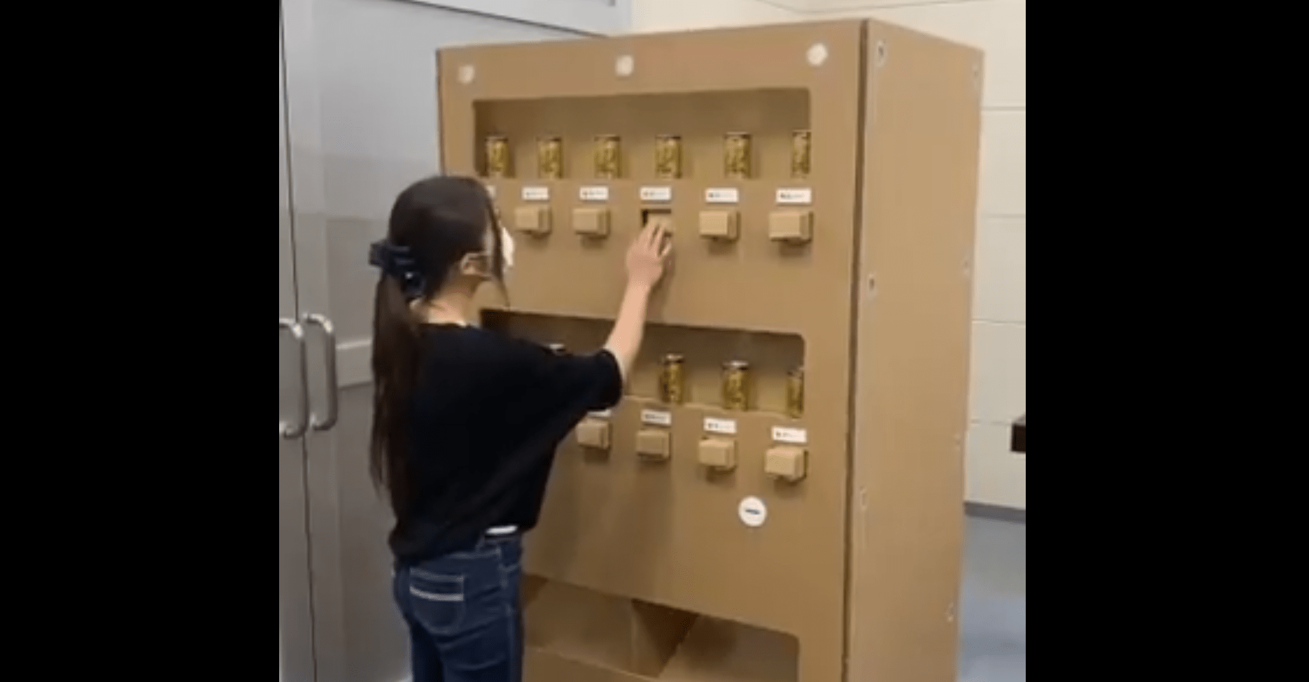 Escritório instala uma máquina de venda automática, feita de papelão, em tamanho impressionante