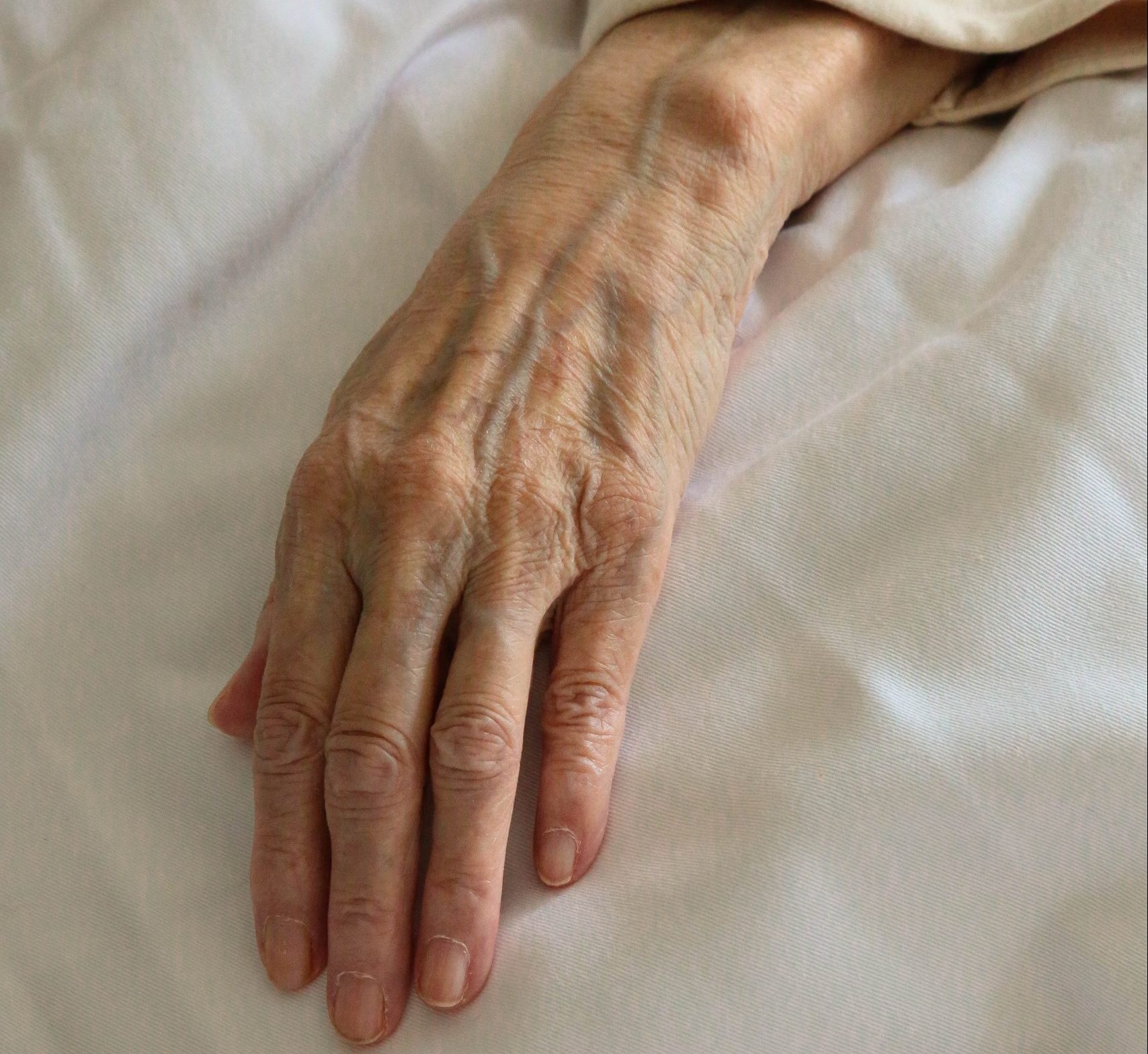 persons left hand on white textile